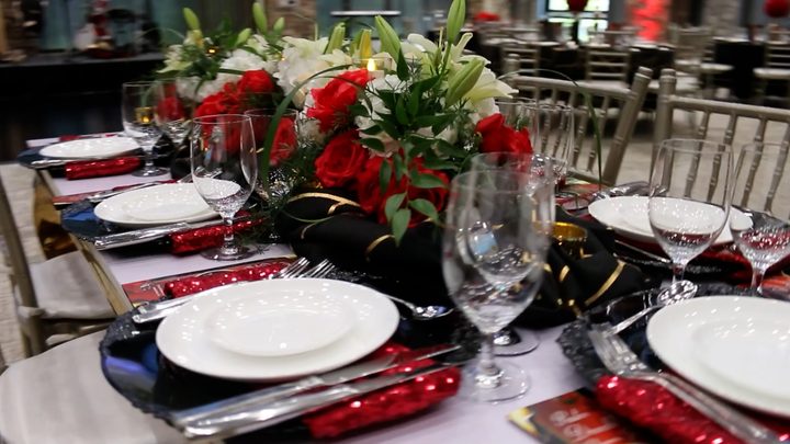 A place setting with red roses and crystal