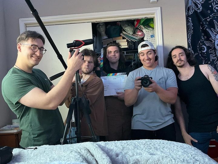 The crew posing behind the camera with the slate on the Beauty Of The Abandoned set