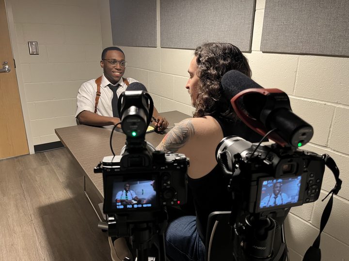 Two camera monitors framing an interrogation scene