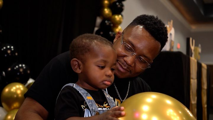 The birthday boy and his dad with a gold balloon
