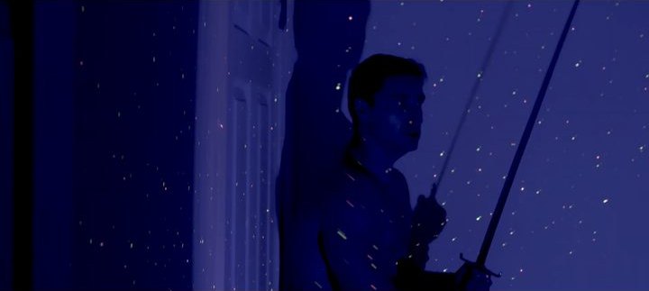 A silhouette at a window in deep blue night light