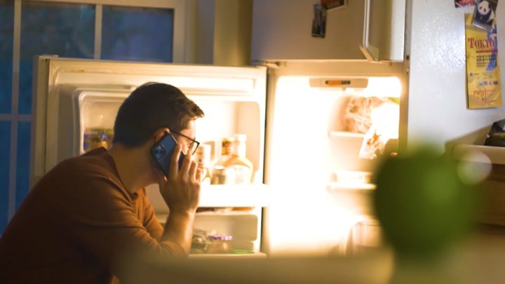 A late-night phone call by the open fridge