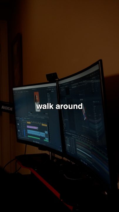 Curved editing monitors glowing in a dim room