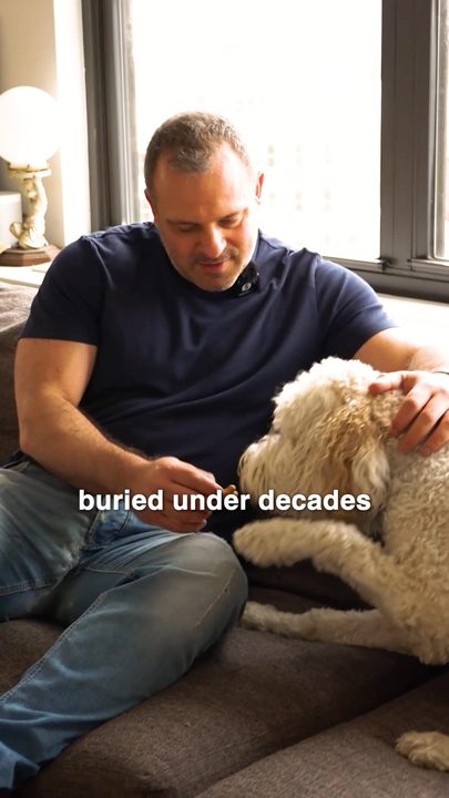 A doctor on a couch with his dog, mid-conversation
