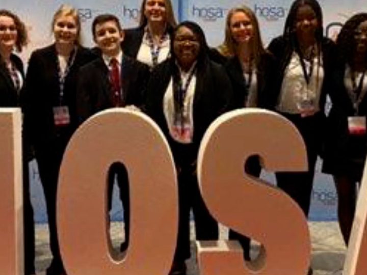 HOSA members posing with giant letters at a conference